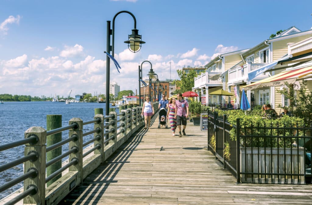 People walking along a waterfront boardwalk.
